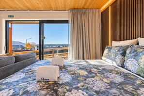 Ein Hotelzimmer mit einem Bett, einer Couch und Blick auf die Stadt.