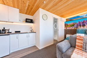 A modern kitchen with white cabinets, a microwave, and a coffee machine. - Aurora Vista | Lake Tekapo Views + Parking (Lake Tekapo)