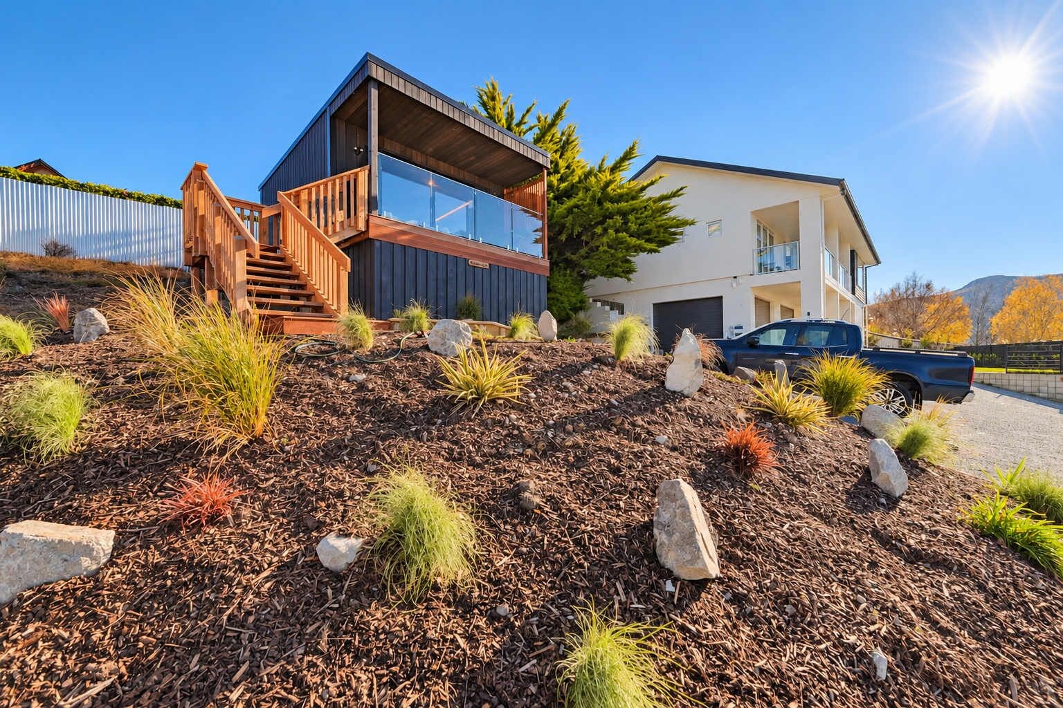 A modern two-story house with a wooden staircase and a balcony.