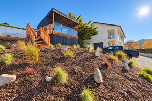 Ein modernes, zweistöckiges Haus mit einer Holztreppe und einem Balkon.