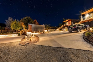 A modern house with a driveway, a car parked in the driveway, and a wooden fence surrounding the property. - Aurora Vista | Lake Tekapo Views + Parking (Lake Tekapo)