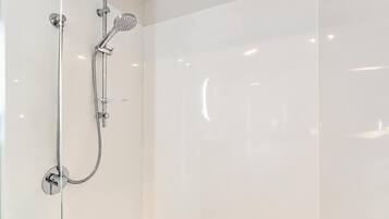 A modern shower with a handheld showerhead and a fixed wall-mounted showerhead.