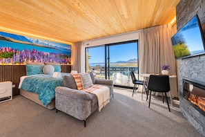 Une chambre d’hôtel moderne équipée d’un lit, d’un canapé, d’un coin repas et d’une cheminée.