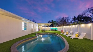 A backyard with a swimming pool, a barbecue area, and outdoor seating. - Heated Pool • Games • Fire Pit • BBQ • Sleeps 12 (Bradenton)
