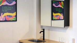 Une cuisine moderne avec un évier, deux verres et un miroir au-dessus du plan de travail.