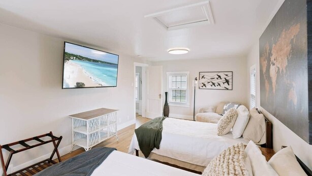 Een hotelkamer met twee bedden, een televisie, een bureau en kunst aan de muren.