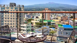Un balcón con vista a un paisaje urbano y una montaña a lo lejos.