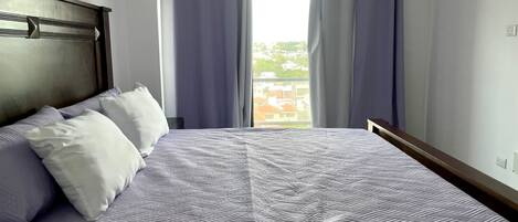 A neatly made bed with a patterned bedspread, a headboard, and two pillows.