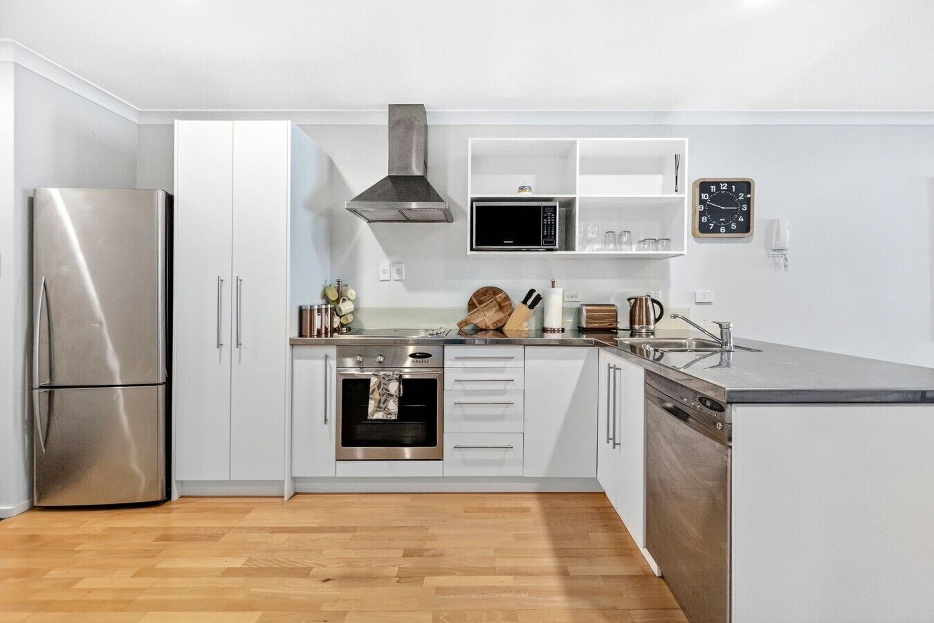 A modern kitchen with a stainless steel refrigerator, oven, microwave, and dishwasher.