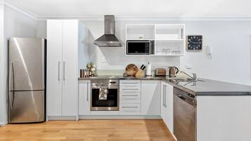 A modern kitchen with a stainless steel refrigerator, oven, microwave, and dishwasher.