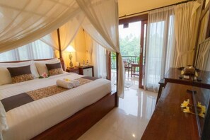 A spacious bedroom with a large bed, a bedside table, a nightstand, and a view of the outdoors. - Room-secret Forest Hideaway Near Ubud (Ubud)