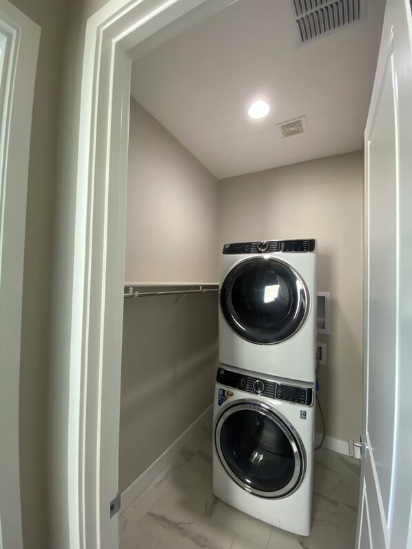 A laundry room with two stacked front-loading washing machines.