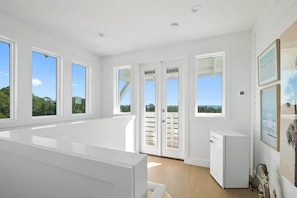 A spacious room with large windows, a white refrigerator, and a door leading outside. - Santa Rosa Beach bliss — biggest & best! (Santa Rosa Beach)