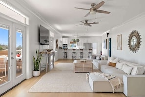 A spacious living room with a white sofa, a coffee table, and a large window. - Santa Rosa Beach bliss — biggest & best! (Santa Rosa Beach)