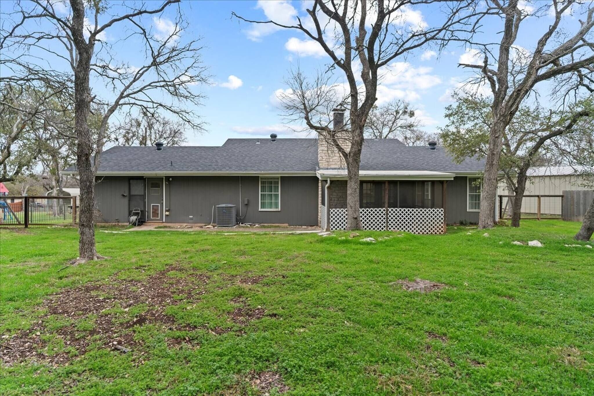 A residential house with a front yard, a garage, and a white picket fence.