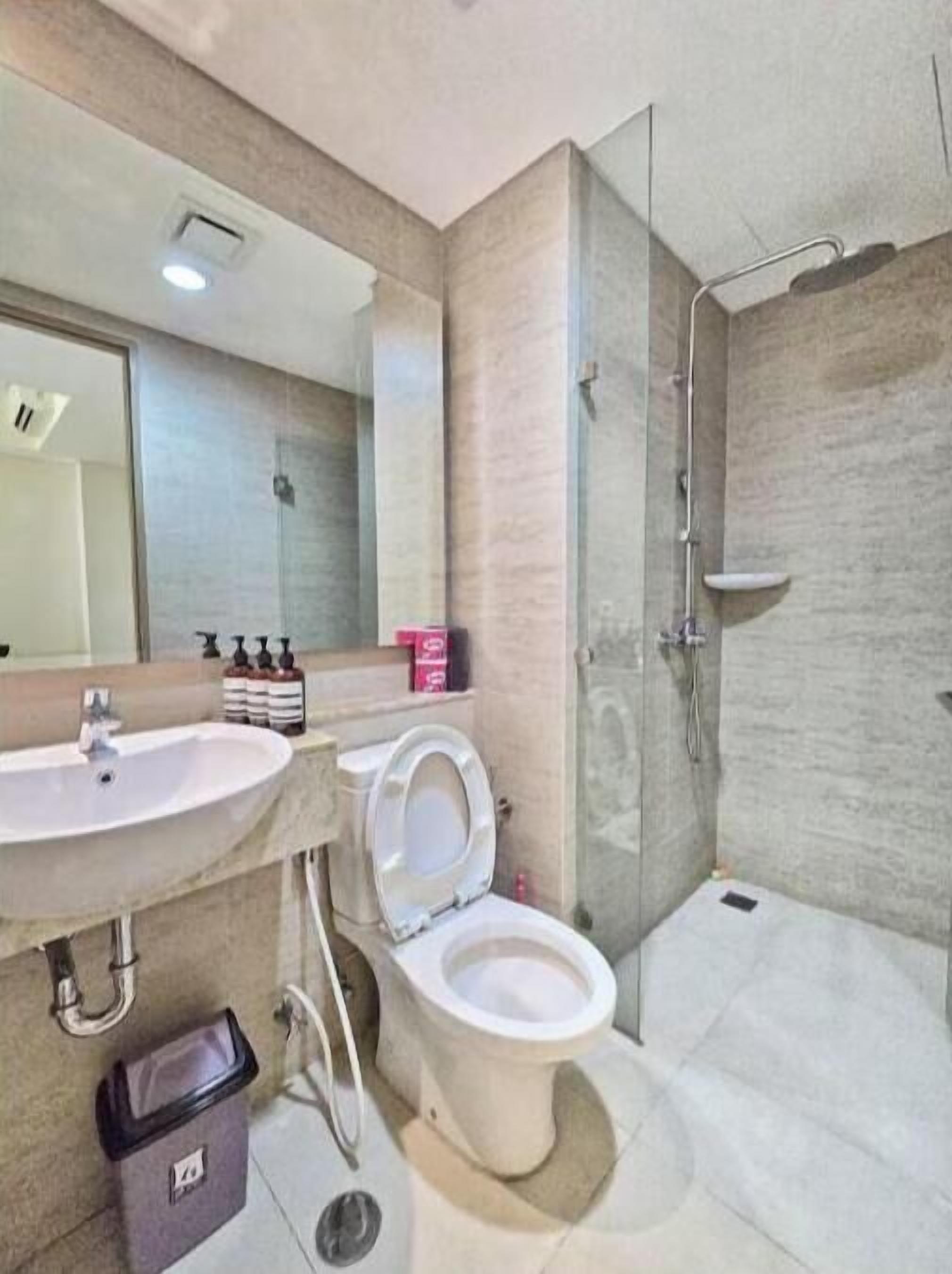 Une salle de bain moderne équipée d’un lavabo, de toilettes et d’une douche.