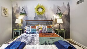 A bedroom with a bed, two nightstands, a wall mural, and a wall-mounted lamp. - Lakefront Poconos 5BR | Hot Tub • Dock • Near Ski (Blakeslee)