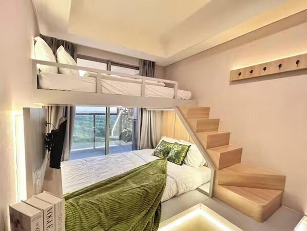 Een moderne slaapkamer met een stapelbed, een trap en een groot raam met uitzicht op de natuur.