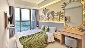 Quarto de hotel moderno com uma cama grande, uma escrivaninha, uma cadeira, um espelho e vista para o exterior.