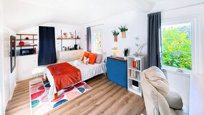 A modern bedroom with a bed, bedside table, and a desk area.