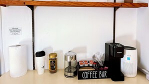 A coffee bar setup with a coffee machine, grinder, and various coffee pods.
