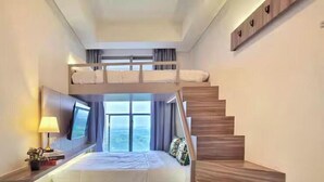 Une chambre moderne avec un lit superposé, un escalier et une table de chevet avec une lampe.