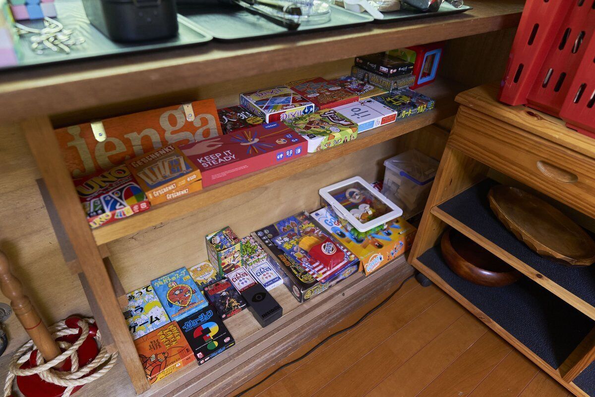 A wooden shelf with various board games and puzzles.