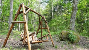 A wooden swing set in a forested area. - A private lodge where you can enjoy authentic BBQ surrounded by nature (Tsumagoi)