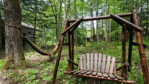 Une balançoire en bois rustique, installée dans une zone boisée au cœur d’un paysage naturel.