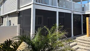 Ein zweistöckiges Haus mit einer Veranda und einem einsehbaren Balkon.