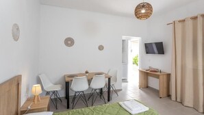 Een moderne hotelkamer met een bed, een bureau, een stoel en een televisie.