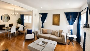 Una sala de estar moderna con sofá, mesa de centro y zona de comedor.