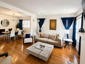 Ein stilvolles Wohnzimmer mit Sofa, Couchtisch und Essbereich.