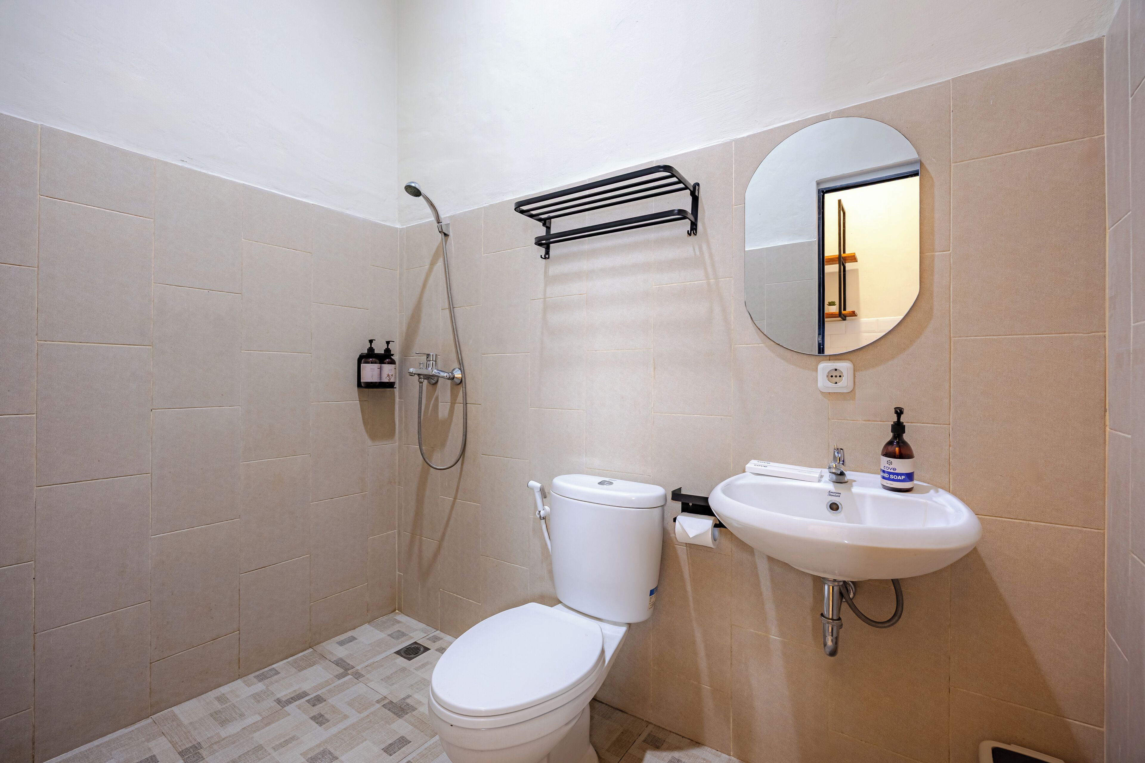 A small bathroom with a toilet, sink, and shower.