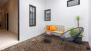 A modern interior with a sofa, chair, and potted plant. - Cove Chara (Jimbaran)