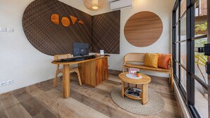 A modern reception area with a wooden desk, computer, and seating area. - Cove Chara (Jimbaran)