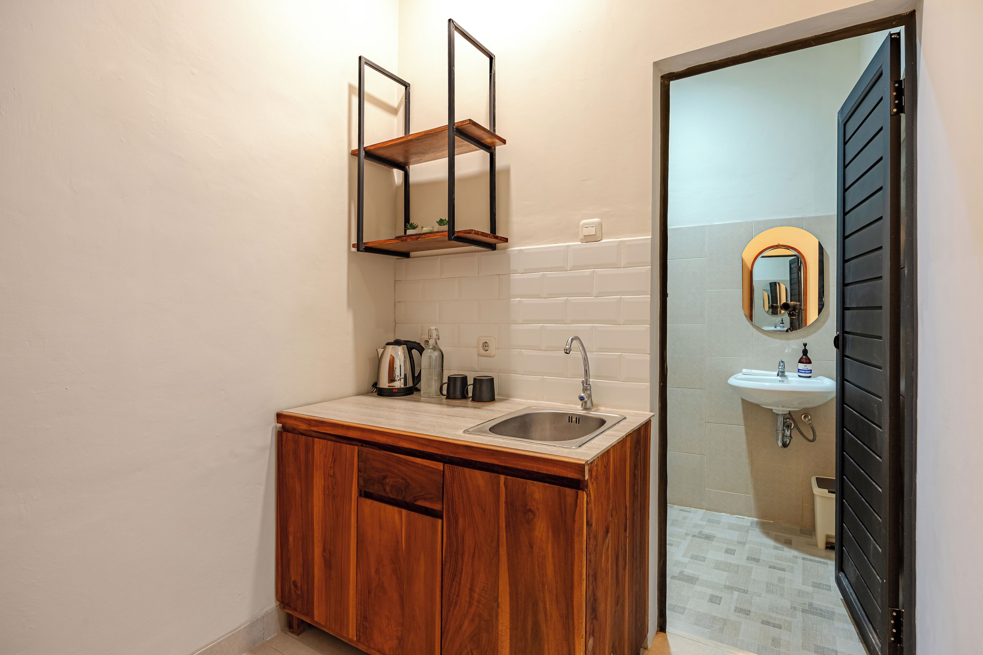 Une petite salle de bain avec un meuble-lavabo en bois, un évier et un miroir.
