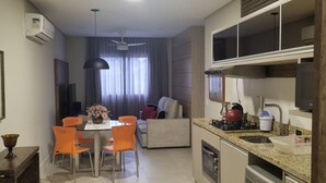 Una cocina moderna con comedor, horno empotrado y ventilador de techo.