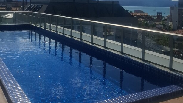 Una piscina en la azotea con vistas despejadas de los edificios y montañas circundantes.