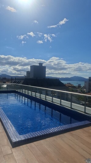 A rooftop pool with a clear view of the surrounding buildings and mountains. - Fully equipped studio apartment 5 minutes from Jurerê Beach. (Florianópolis)