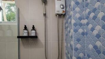 A bathroom with a shower, a toilet, and a shelf with toiletries.