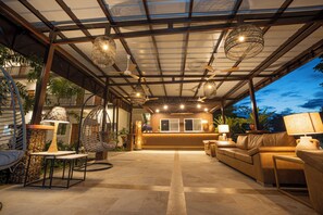 A spacious lobby with a reception desk, comfortable seating, and hanging wicker lamps.