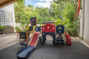Ein Spielplatz mit Basketballkorb, Rutschen und Klettergerüsten.