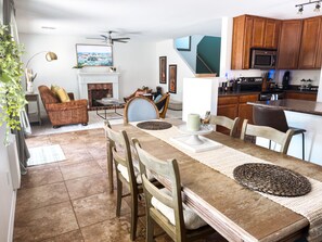 A dining area with a wooden table, chairs, and a fireplace. - Spring Training HQ · Real Grass · Game Room · Pet Friendly · Sleeps 8 (Sun City)