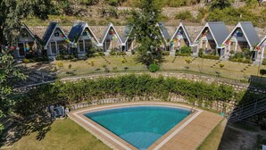 Ett poolområde med en klarblå pool som omges av en poolterrass med kakelplattor.