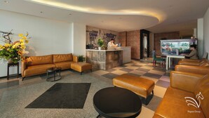 Un lobby moderno con sofás de cuero, un mostrador de recepción y un suelo a cuadros.