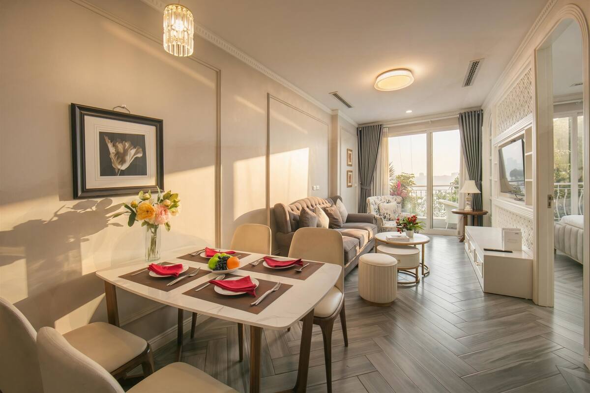 Un comedor con una mesa dispuesta para cuatro personas, un sofá y un balcón con vistas.