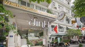 Un edificio con un cartel que indica 'Westlake Pearl Suites & Spa' y 'JinH Beauty & Clinic' en la planta baja.
