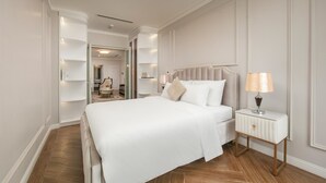 Un dormitorio ordenado con una cama grande, mesitas de noche y una lámpara.