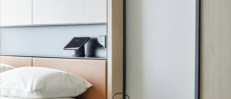 A hotel room with a bed, a small table with a tea set, a chair, and a wardrobe.